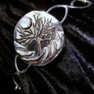 A sterling bracelet, fabricated overlay of silver on silver forming a tree with a moon of cabochon moonstone. c.2008