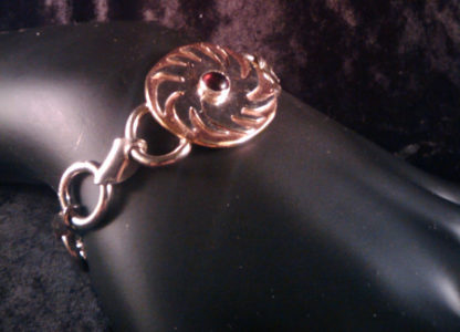 A sterling bracelet, fabricated overlay of silver on copper forming a sunburst with a center of cabochon carnelian. c.2008