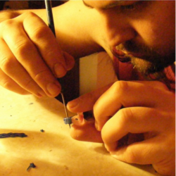 Hand sculpting a Claddagh ring in wax to be cast in sterling silver. Hand sculpting a Claddagh ring in wax.